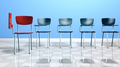 Stuhlreihe und roter Stuhl im Flur