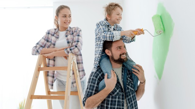 Eine Familie streicht gemeinsam die Wände