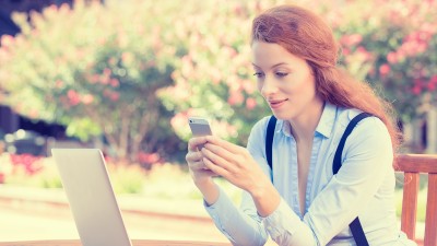  Frau hält, nutzt Smartphone, Handy und Computer